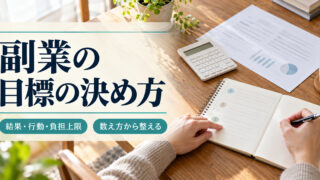 「副業の目標の決め方」の見出しと、電卓や資料を置いた机で三つに分けたノートの欄を確認する手元
